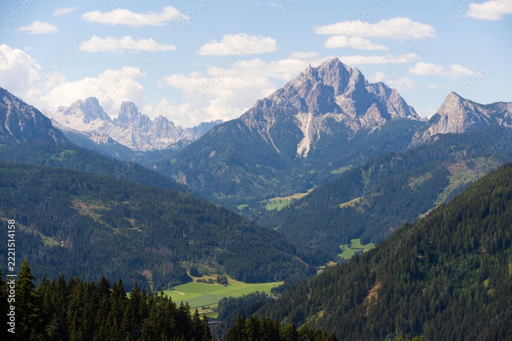 Fototapeta premium Majestic scenery of rough mountain ridge near grassy hills 
