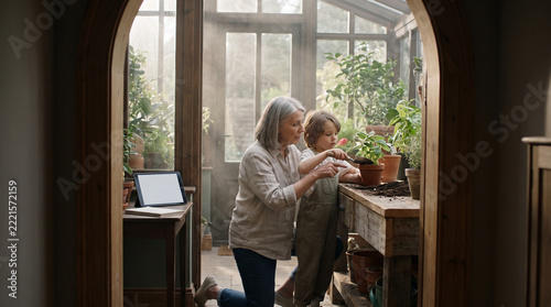 Grandmother and Child Gardening in Sunlit Greenhouse