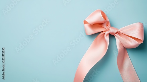 Stylish pink ribbon bow placed on a gentle blue backdrop perfect for gifts and decorative purposes