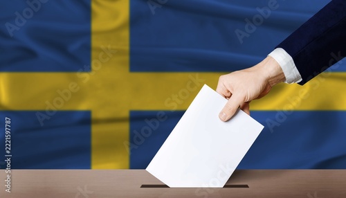 Sweden Parliamentary vote 2026. Hand placing a ballot in ballot box with the Swedish flag in the background