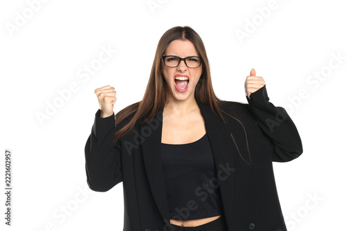 Studio shot of furious brunette business woman in black blazer, black top and eyeglasses shouting with clenched fists, half body, on white background