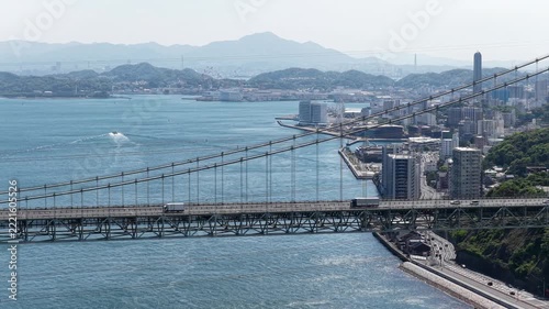 Aerial drone footage hovering over Kanmon Bridge and Kanmon Strait in Japan