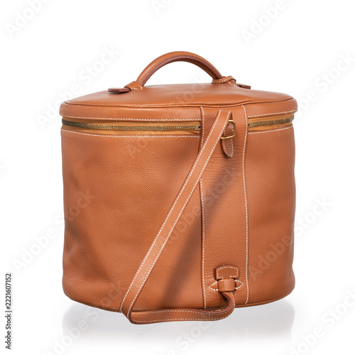 Brown leather cylindrical beauty case with gold hardware, lock, and clasp. Photographed against a white background.
