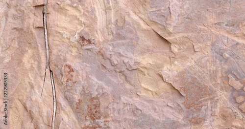 Weathered Rock Surface with Beige and Lavender Mineral Patterns and Natural Cracks