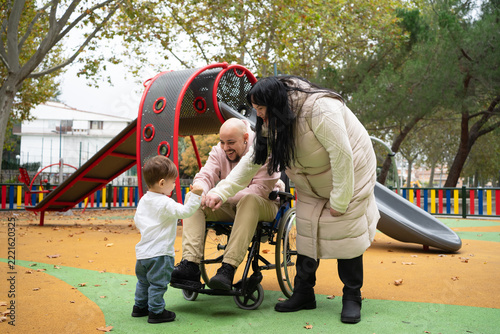 Family bonding at playground with parent using wheelchair