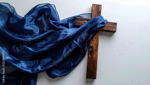 Wooden cross draped with flowing navy blue fabric, symbolic decorative concept