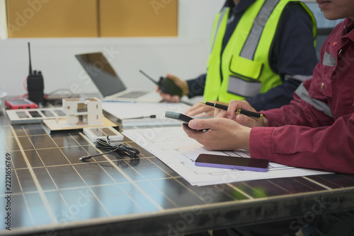 Solar panel, technician, blueprint, radio, safety, planning at worktable with protective clothing and technical equipment