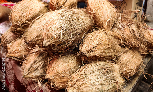 Pile of Raw Brown Coconuts with Husk for Puja Offering