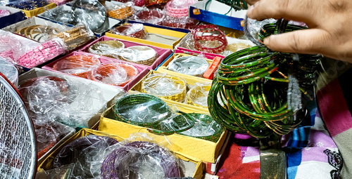 Customer Selecting Traditional Green Glass Bangles at Local Indian Market
