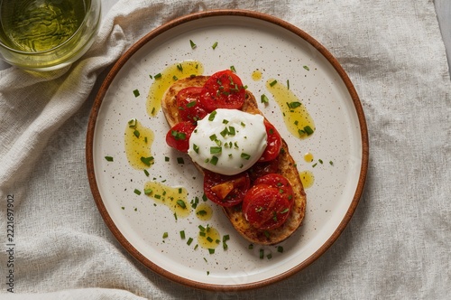 Toasted sourdough with burrata and roasted tomatoes in airy Mediterranean brunch scene