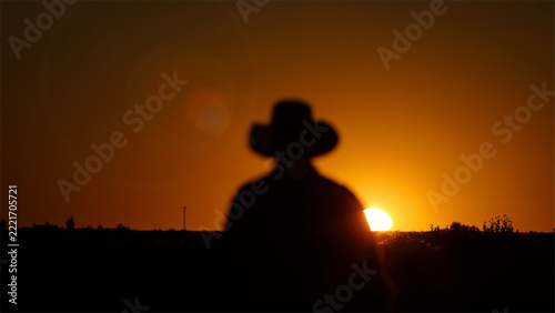 Outback farmer, bush hat, sun silhouette in dry hot El Nino drought