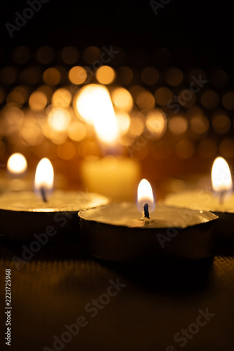 Glowing Candle Flame in Warm Bokeh for All Saints Day Memorial
