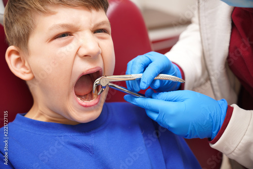 Child gets dental care in a clinic as a dentist works on the teeth with dental tools during a check-up