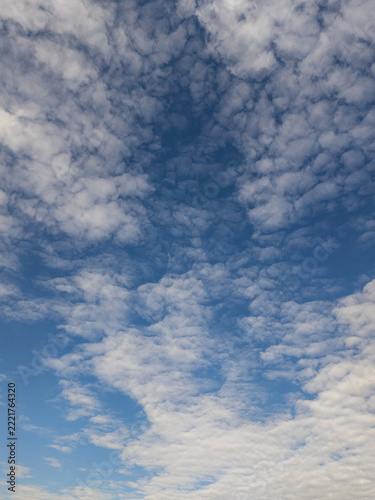 Scattered white clouds drift across a vivid blue sky