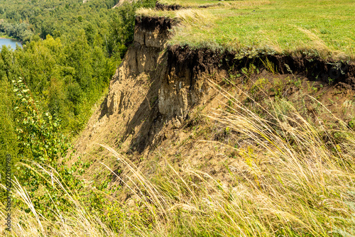 The steep, almost sheer riverbank looked stern and majestic against the overcast sky.