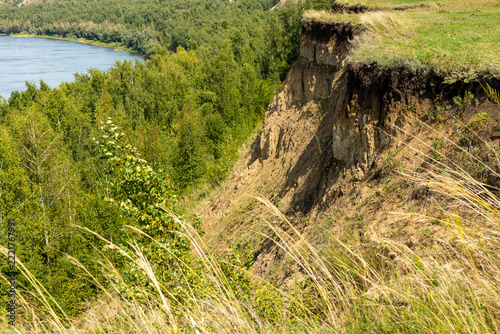 The steep, almost sheer riverbank looked stern and majestic against the overcast sky.