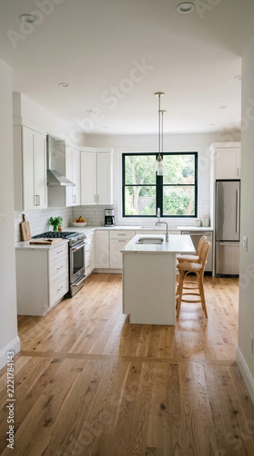 Modern White Kitchen Island with Wooden Floor Natural Light and Greenery View from Window
