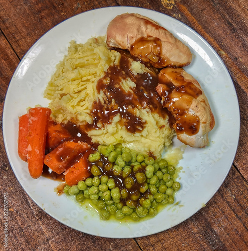 roast chicken  with mashed potatoes carrots peas and gravy