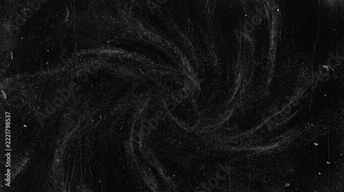 Abstract dark grunge background with swirling dust particles and vintage film scratches