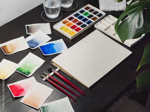 Professional watercolor swatches artist workspace setup. Watercolor swatches artist workspace with blank paper sheet and brushes. Clean watercolor swatches artist workspace displays painting