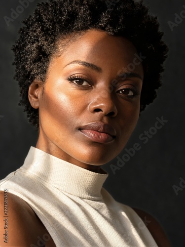 Dramatic beauty closeup of woman with warm window light and deep facial shadows