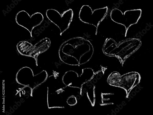 Hand drawn white chalk hearts and love text set on black background illustration