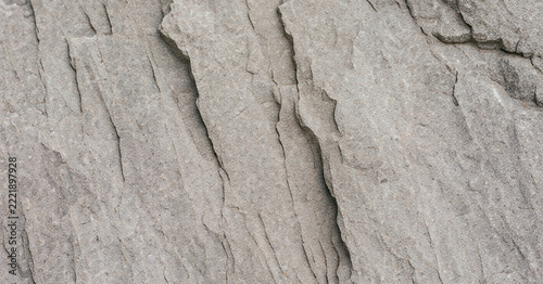 Close-up view of textured rock surface showing layers and grooves, perfect for nature themes and geological studies.