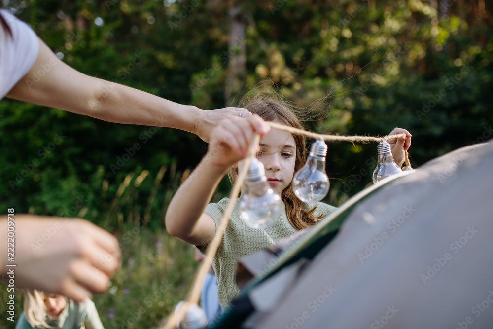 Fototapeta premium Dad and kids setting up tent together during summer camping trip.