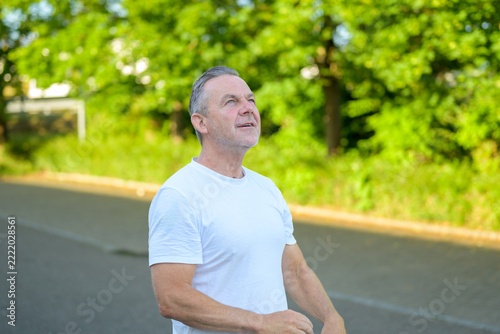 Optimistic mature man outdoors looking upward