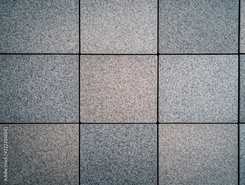 Close-up view of nine granite tiles arranged in a 3x3 grid with visible textures and subtle color variations.