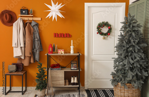 Christmas home interior, festive holiday entryway decoration with tree and wr...