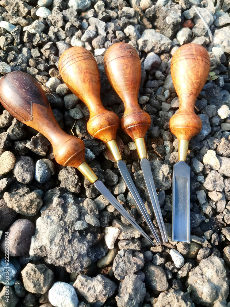 Fotografie Artisan wood carving gouges and chisels on gravel background.