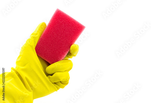 Close view of a hand wearing a yellow rubber glove holding a pink sponge against a clean white background, illustrating household cleaning, hygiene, and sanitation