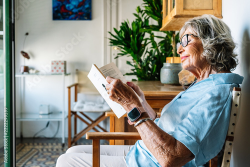 Senior woman relaxing at home reading book