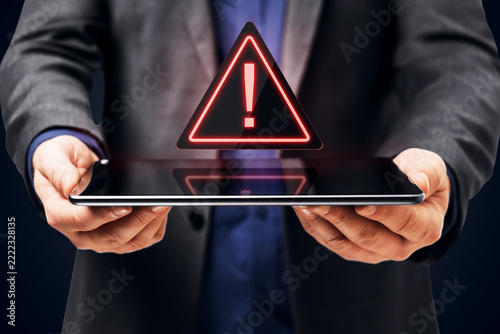 Businessperson Holding a Tablet with Glowing Exclamation Warning Symbol for Digital Security, Online Alert, Mobile Technology and Risk Awareness.