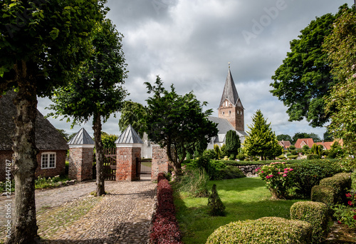 View of a street, a church, and a cemetery in a Danish village
