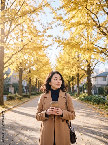 Woman Walking Down Golden Autumn Avenue in City