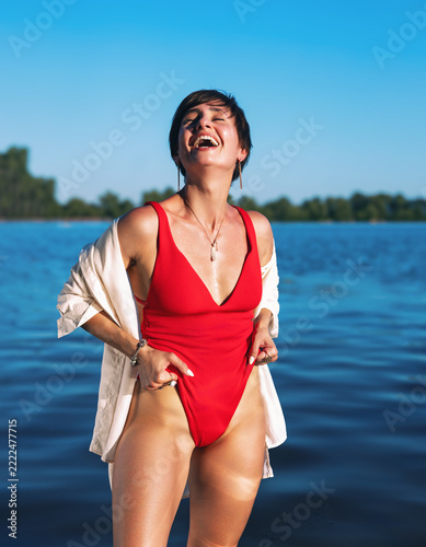 Stylish Woman in Red Swimsuit Posing by the Sea on a Summer Vacation, Beach Fashion and Travel Lifestyle
