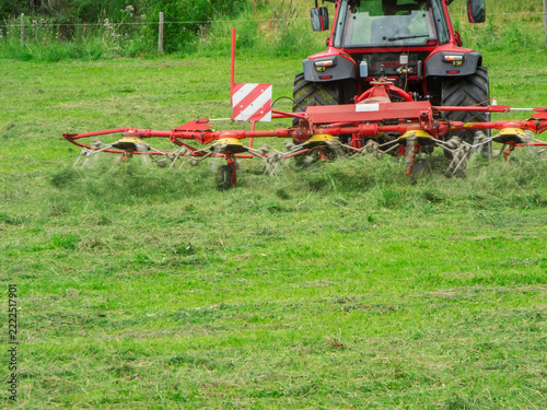 Tractor with hay turner at work rear side