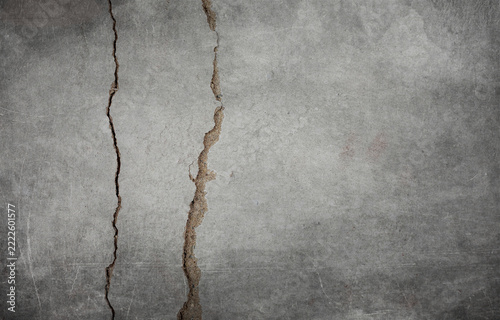 Gray plastered concrete wall with cracks.