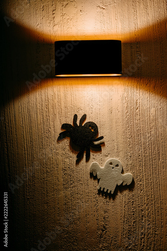 Halloween spider and ghost silhouette on textured wall