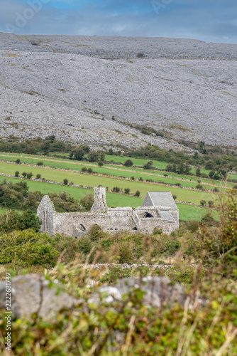 Vertical shot of the medieval cistercian Corcomroe Abbey ruins nestled in the karst limestone landscape of the Burren in County Clare, Ireland.