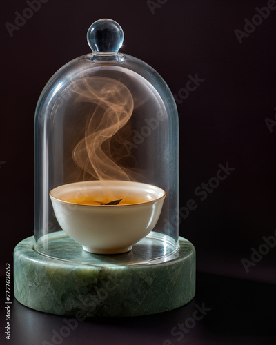Tasse de thé fumant sous une cloche en verre