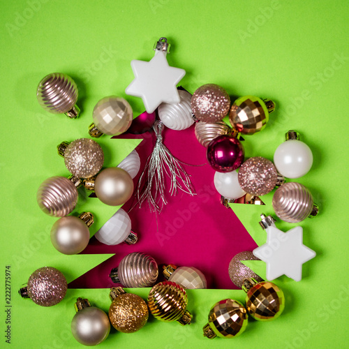 Festive ornament arrangement spells out tree on vibrant green surface