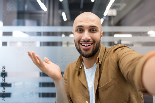 Smiling man doing video call greeting colleagues online