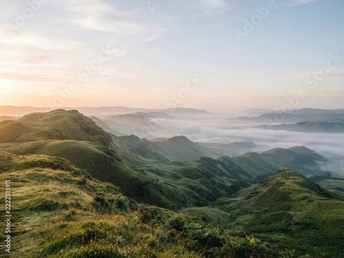 Rolling emerald green hills descending into a misty valley