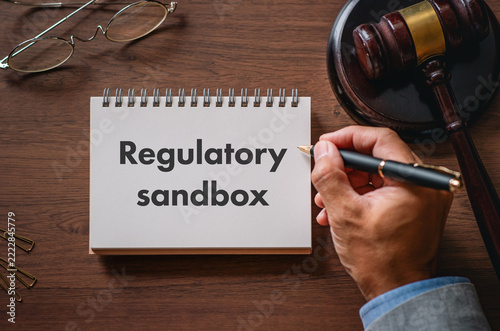 Obraz na plátně Regulatory sandbox innovation strategy: lawyer's desk setup with gavel and spira