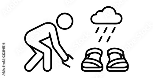 Person bending down in rain with shoes nearby with shoes placed