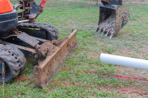 Heavy excavator digs trench for drainage pipe at Construccion site during excavation work.