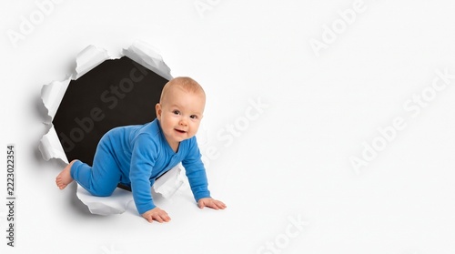 An all-white image with a tear in the corner, from which a crawling child is emerging.